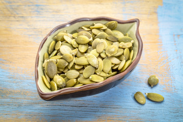 raw pumpkin seeds in a leaf bowl