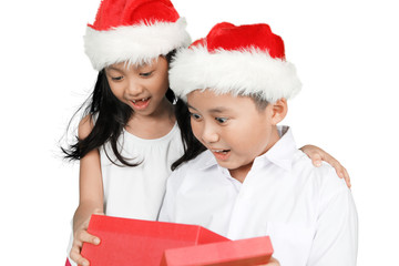Two amazed children open Christmas presents