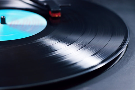 vinyl disc spinning on turntable with needle detail