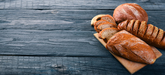 Assortment of bread and baking. On a wooden background. Top view. Free space for your text.
