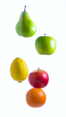 Isolated apples, orange, lemon, and pear dropped from top