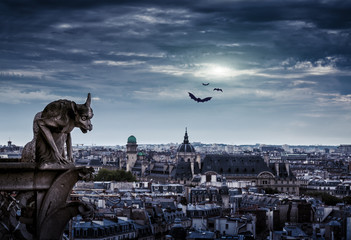 Gargoyle of Notre Dame de Paris on Halloween, France. Fantasy night city.
