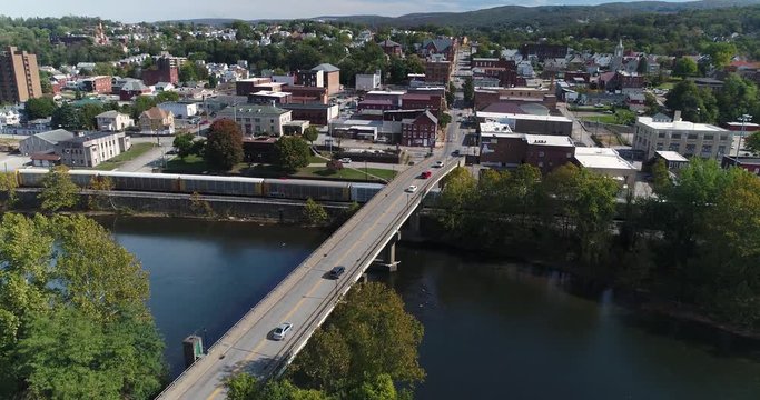 A slowly moving forward aerial shot of the small town of Connellsville, Pennsylvania while traffic travels on the Officer McCray Rob Memorial Bridge over the Youghiogheny River.  	