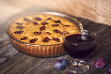 homemade jam with plum pie on wooden background