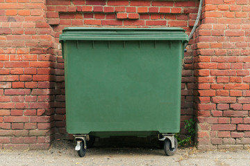  city green garbage container rubbish bin dustbins outside against brick wall background with copy space