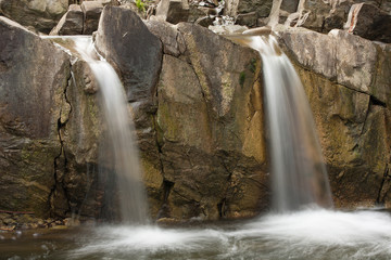 Two small waterfalls that formed naturally on a mountain river flowing among the rocks