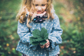 portrait of a little curly-haired girl in the woods