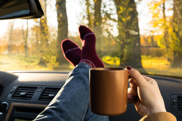 Autumn car trip. Warm wool socks and cup of tea in the car