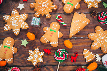 Christmas gingerbread cookies homemade on wooden table with candies and New Year decorations. Xmas background
