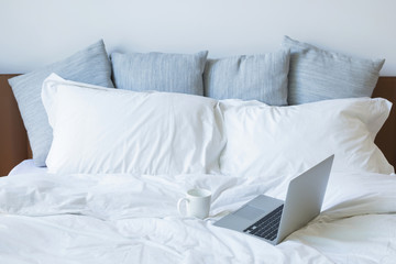 Laptop pc and cup of coffee on the bed - obrazy, fototapety, plakaty