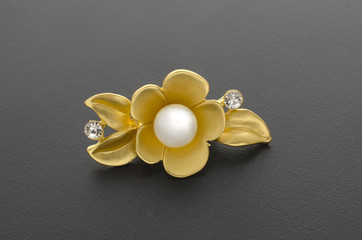 Fototapeta na wymiar gold brooch flower with pearl isolated on black