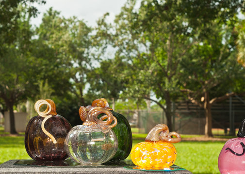 Hand blown colored glass pumpkins on display and for sale at an autumn art festival