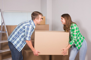 Fototapeta na wymiar Happy young couple unpacking or packing boxes and moving into a new home.