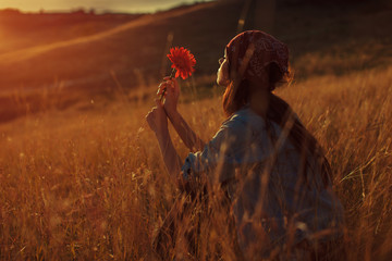 Young woman hold flower and enjoy the sunset in nature