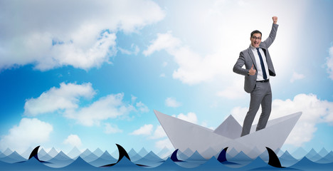 Excited businessman riding paper ship boat