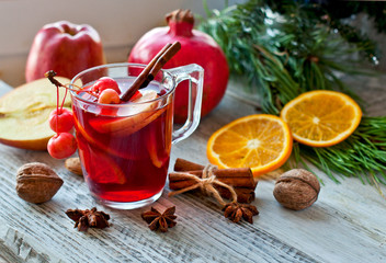 Mulled wine, winter drink, fruit and Christmas decor on a wooden background. Festive cocktail