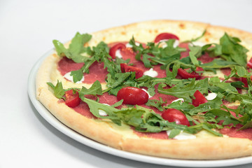 Pizza with prosciutto (parma ham), arugula (salad rocket) and parmesan isolated on white background. Italian cuisine