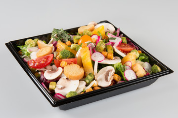 Salad in takeaway container on white background
