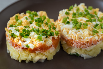 Herring under the coat -  multilayer salad from herring, potatoes, carrots and eggs decorated with chives.