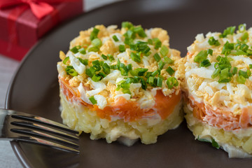Szuba - herring under the coat -  traditional multilayered polish salad from herring, potatoes, carrots and eggs decorated with chives.