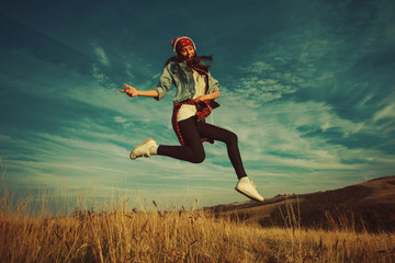 Fototapeta na wymiar Happy young woman jump in the air in nature