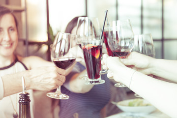 People toasting with glasses of red wine, closeup