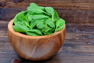 Fresh green baby spinach leaves in a bowl on table