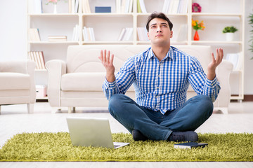 Young handsome man sitting on floor at home