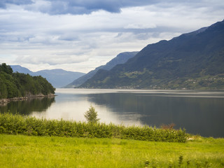 Fototapeta premium Paisajes de agua, montañas, y prados en la zona de ODDA a JONDAL en el sur de Noruega a orillas del fiordo Hardangerfjorden. Vacaciones de verano de 2017