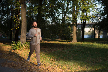 Obraz premium Healthy man running in the morning. Jogger in sport wear in the park.