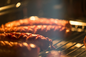 Delicious homemade baked sausage in oven with shallow depth of field.