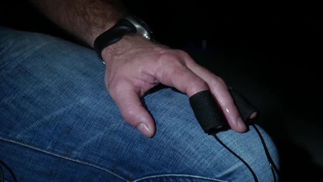 Man with sensors on finger bouncing leg
