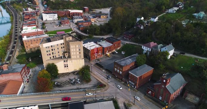 A aerial daytime exterior (DX) establishing shot of the business district of the small town of Brownsville, PA - a Pittsburgh suburb on the Youghiogheny River.  	