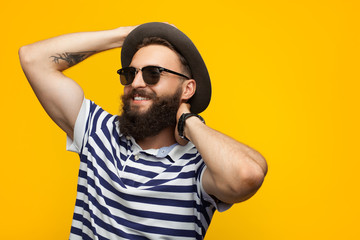 Naklejka premium Young hipster man posing on orange