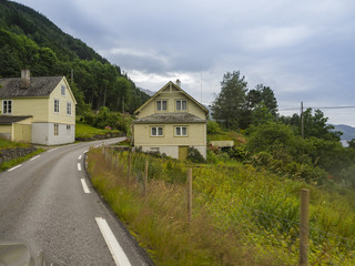 Fototapeta na wymiar Paisajes noruegos con casas típicas de madera y vegetación verde, en la zona de ODDA a JONDAL en el sur de Noruega a orillas del fiordo Hardangerfjorden, Vacaciones de verano de 2017