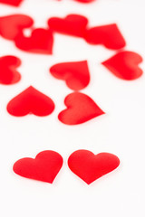 Two red hearts isolated on white background with red hearts in the background