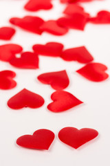 Two red hearts isolated on white background with red hearts in the background