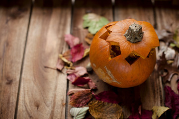 pumpkin  for the autumn holiday. on a wooden brown background with autumn leaves