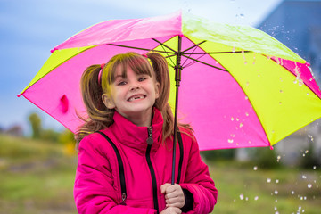Girl with an umbrella are enjoying rainfall in autumn day