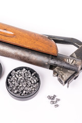 Box with metal air gun pellets and air gun with wooden kundak gunstock above white background