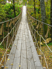 Fototapeta na wymiar Suspension bridge in the forest.