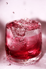 Splashes and drops in the glass of red water