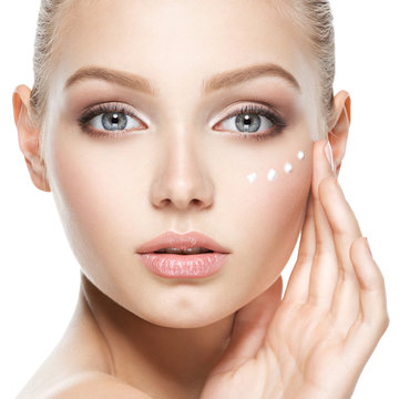 Beauty face of woman with cosmetic cream on face