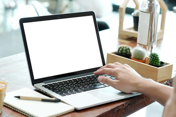 Man hands typing laptop computer with blank screen for mock up while sitting in the cafe, technology and lifestyle concept