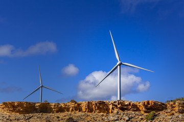 Two wind turbines with vivid blue sky as background and copy space
