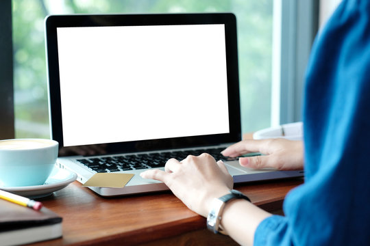 Woman hands typing laptop computer with blank screen for mock up while sitting in the cafe, technology and lifestyle concept