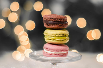 Three macaroons on glass stand bokeh background 