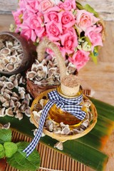 Moringa oleifera oil and seeds on wood background