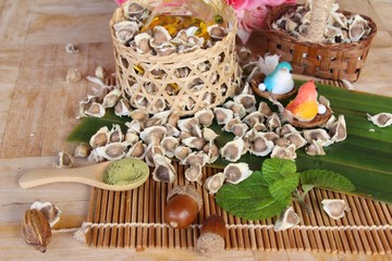 Moringa oleifera oil and seeds on wood background