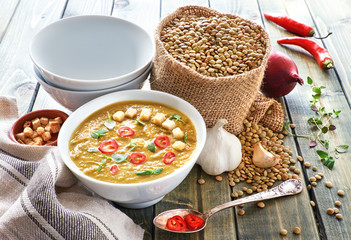 Spicy lentil soup with chili, garlic and onion on the wooden table